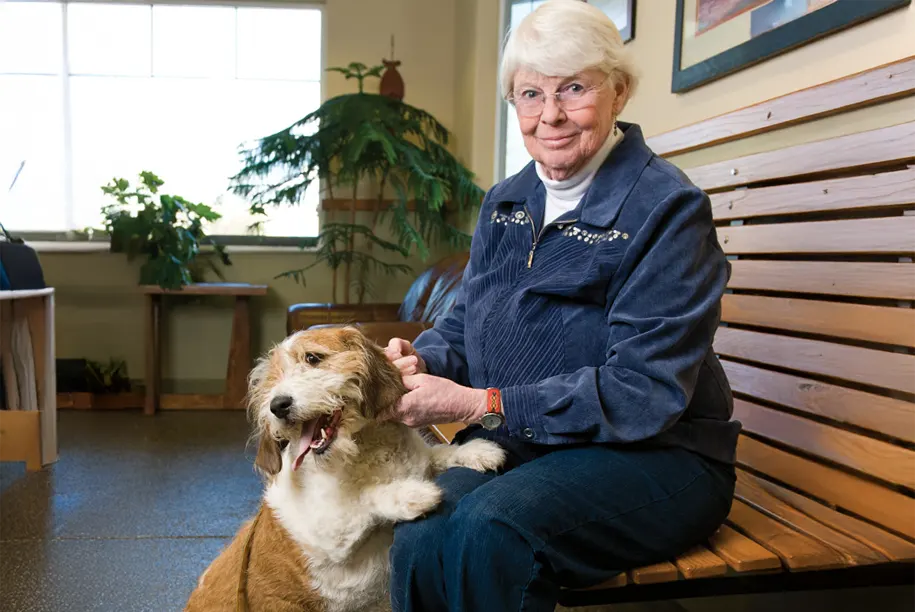 Woman waiting in the lobby with her dog at Lakewood Animal Hospital
